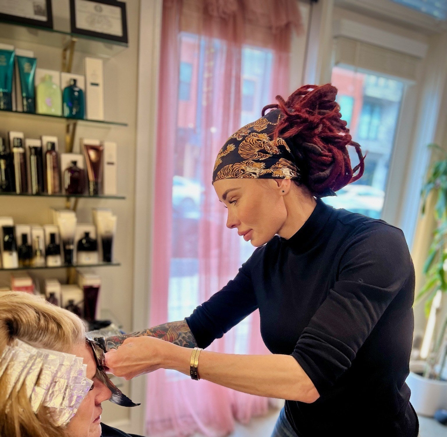 Tina, founder and Master Colorist, coloring a guest's hair at Ārdeō Color Studio in Mueller, Austin, TX